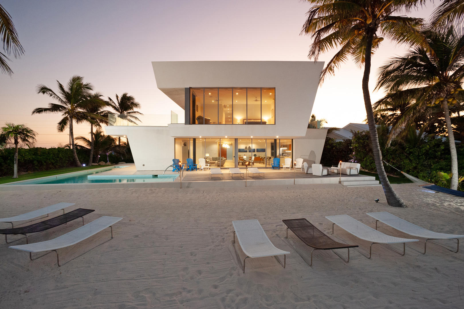 Beachfront side of villa at sunset hour.