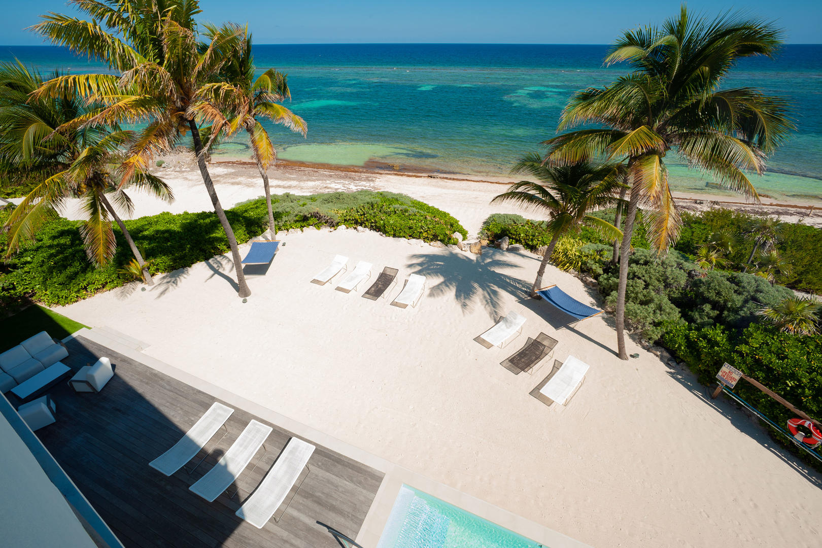 Private beach area with hammocks and chaise loungers.