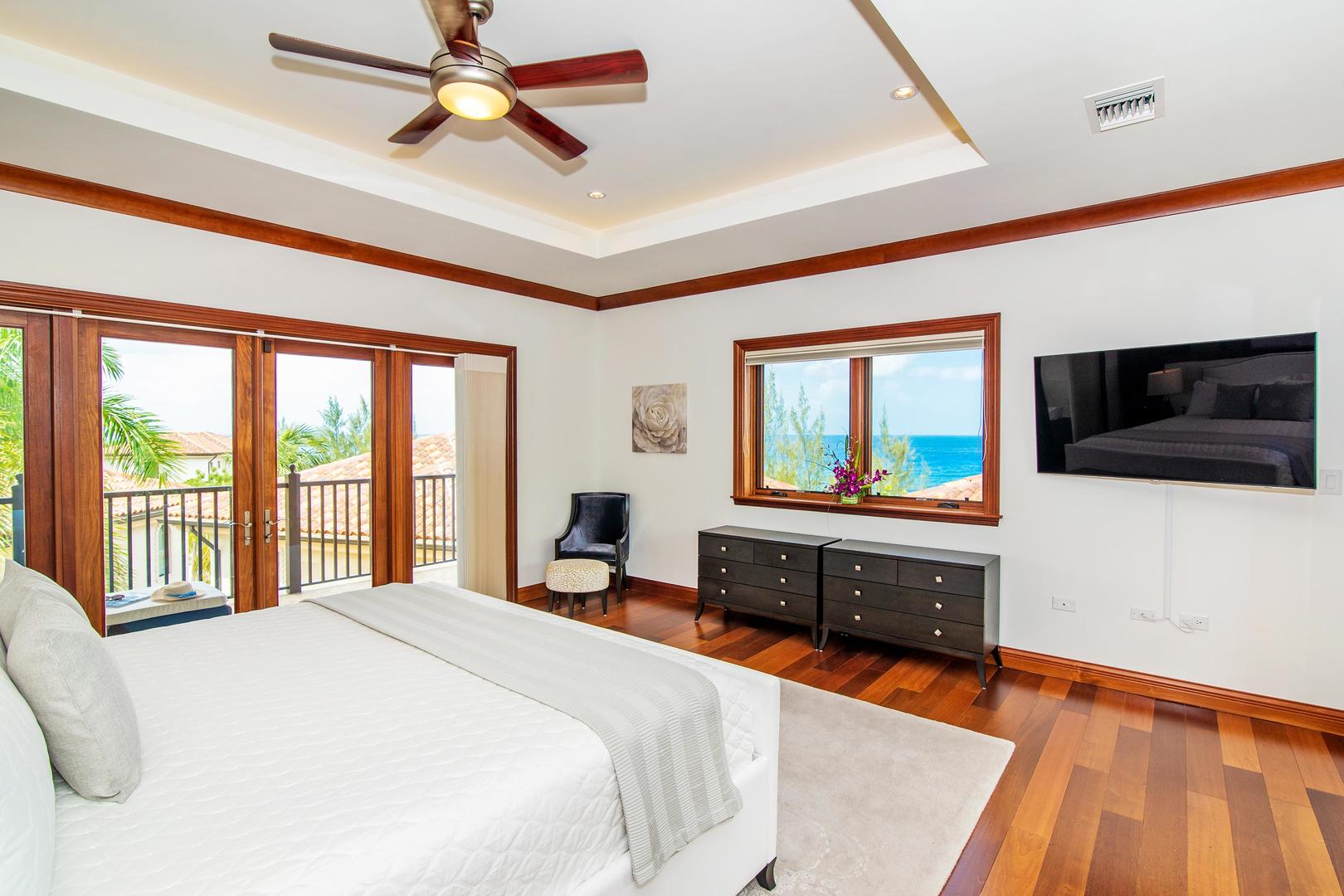 Master suite with ocean views, king bed, TV, and private terrace.	