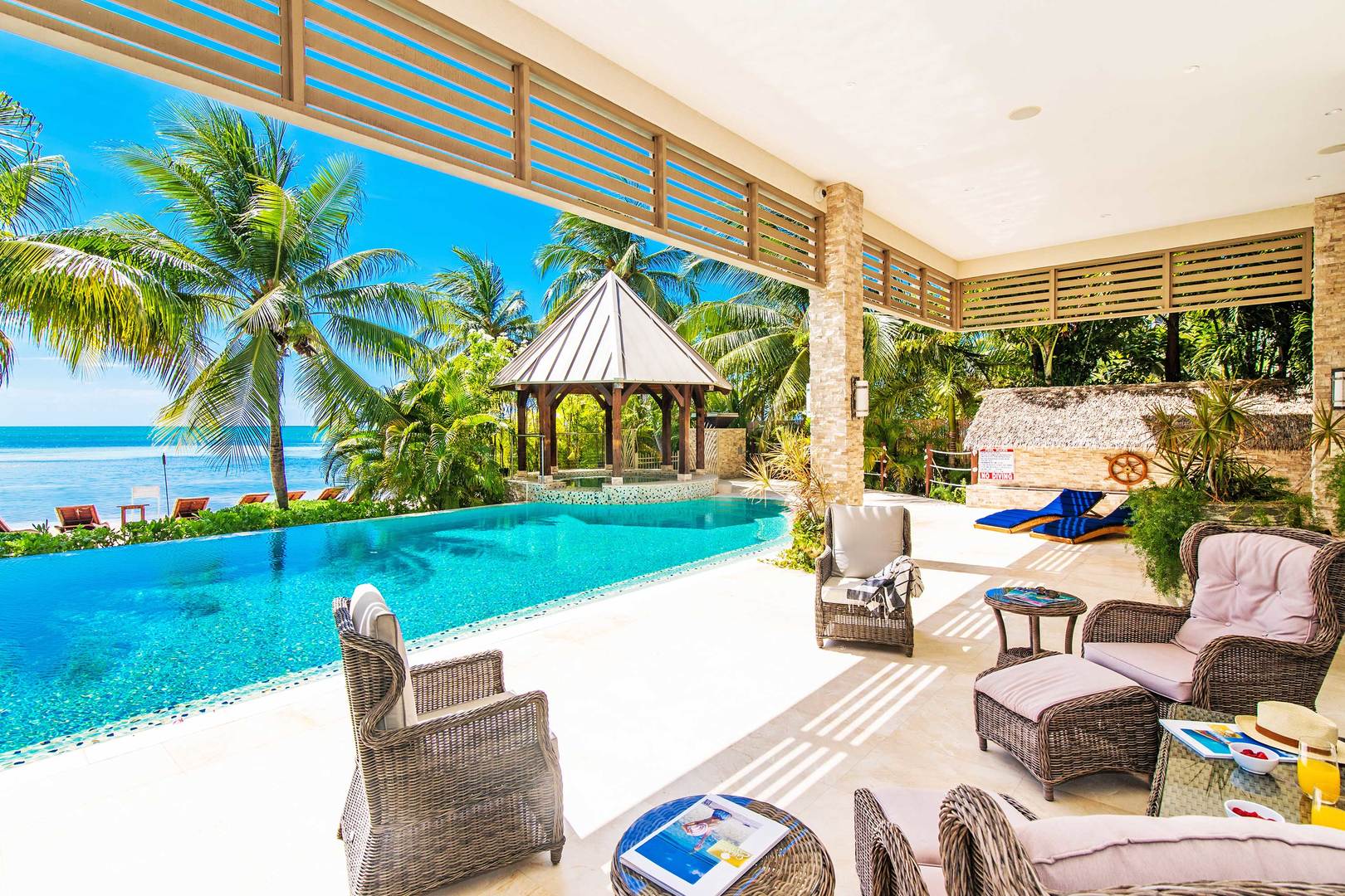 The stunning veranda looks over the pool and features a beautiful view of the deep blue sea.