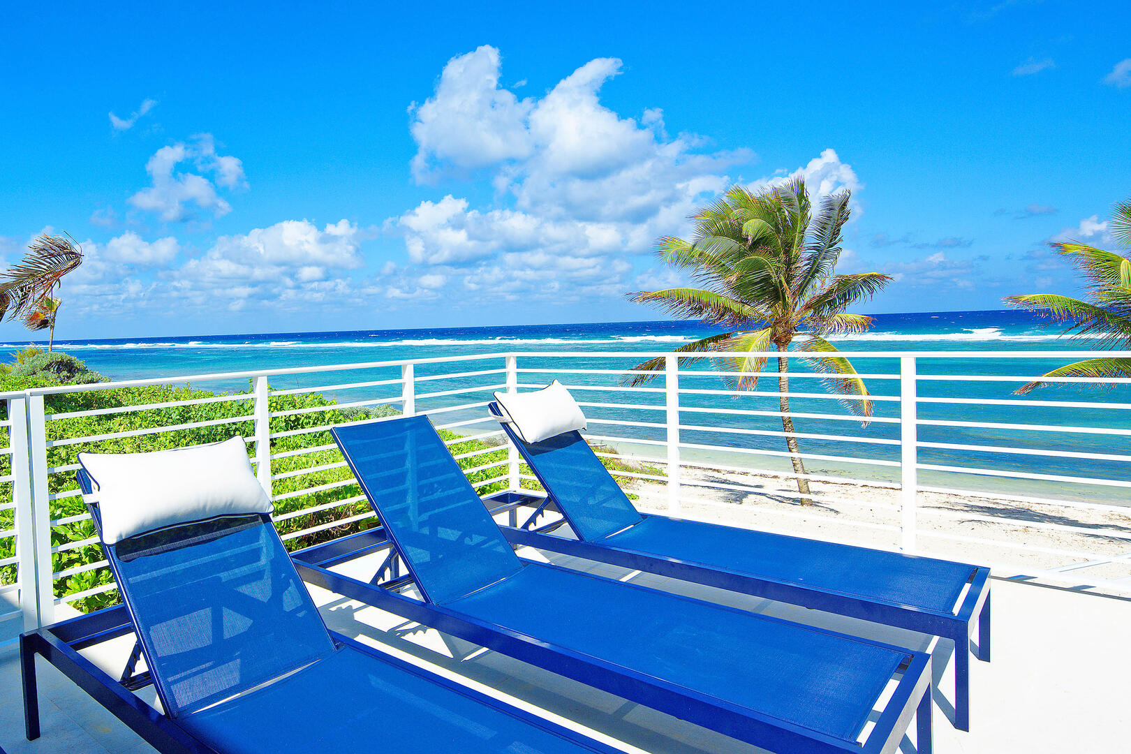 Lounge by your private pool with a stunning view of the Caribbean.