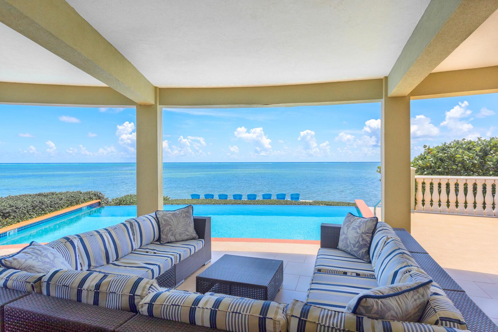 Large oceanfront pool deck with a veranda for shade.
