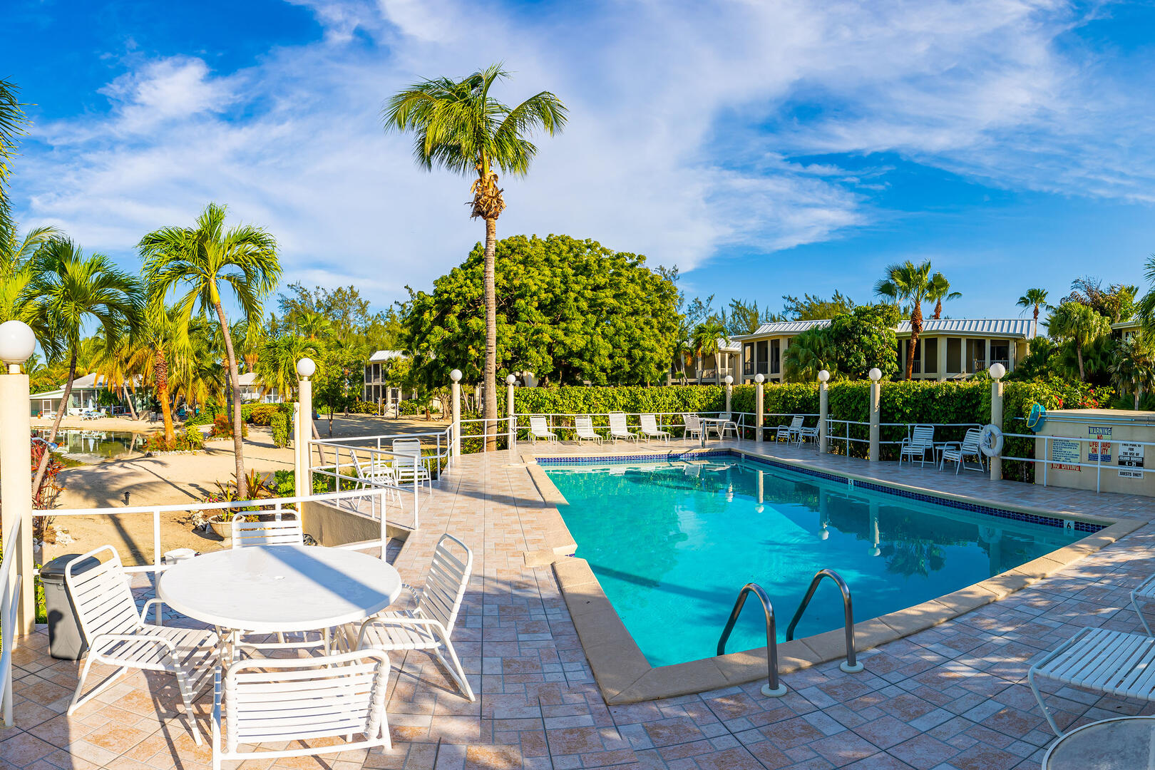Shared pool deck with sun loungers and outdoor furniture. 