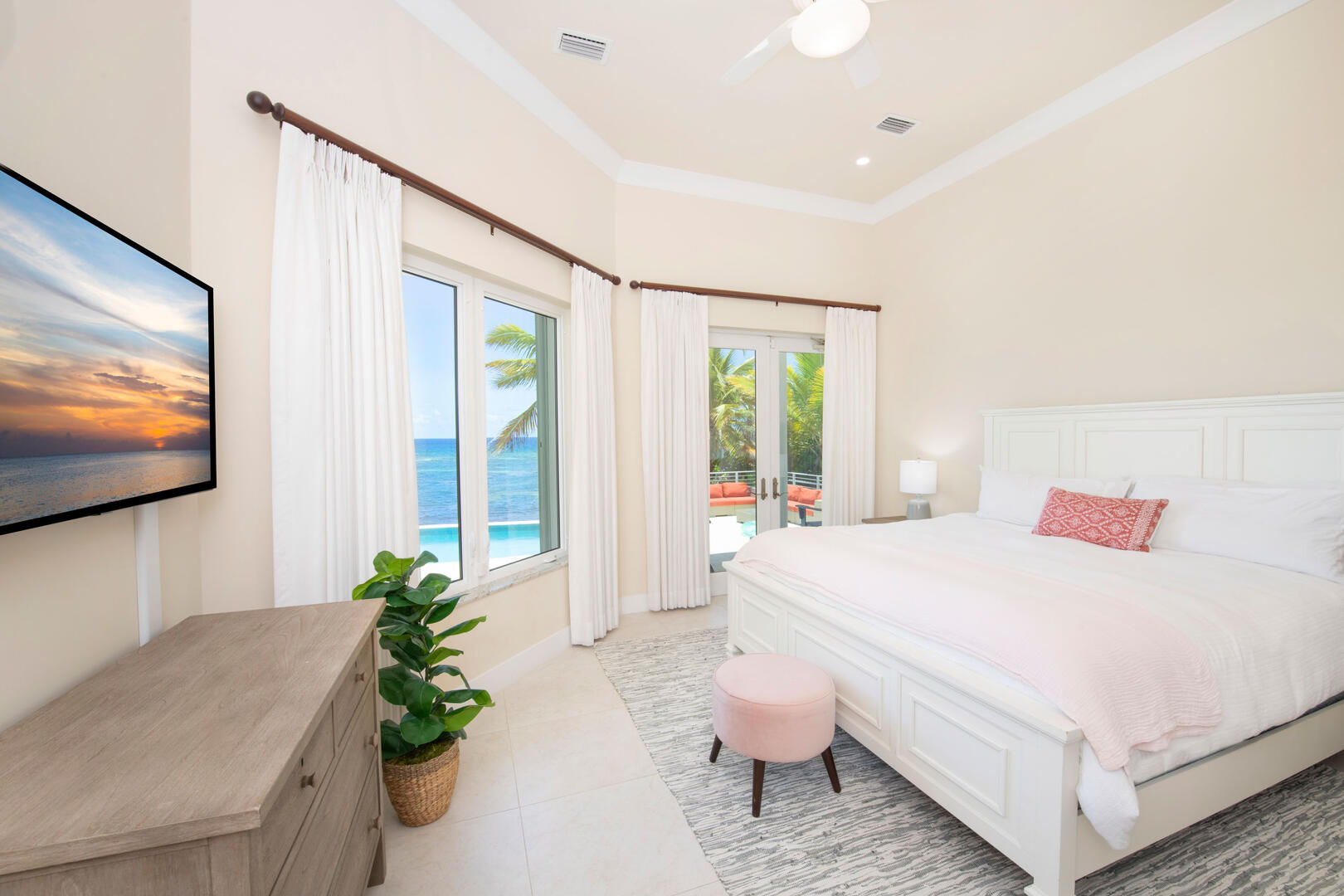 Guest Suite #2 with king bed, ocean views, television, and walkout access to the pool deck. 