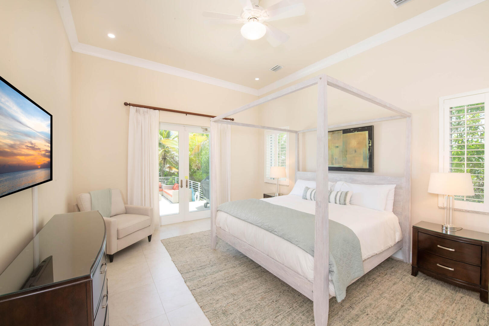 Guest Suite #3 with king bed, ocean views, television, and walkout access to the pool deck. 