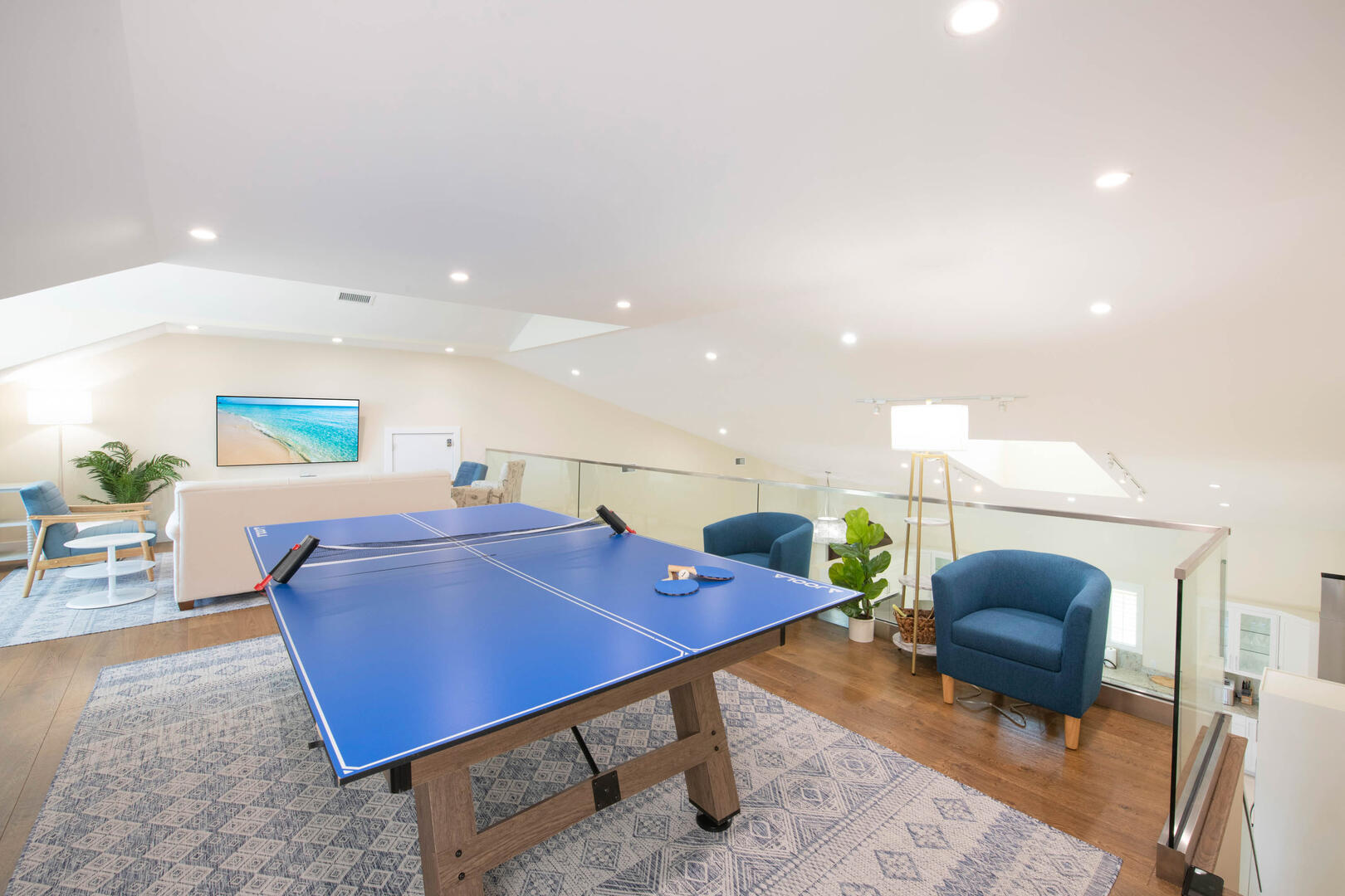 Loft area game room with ping pong table and television. 