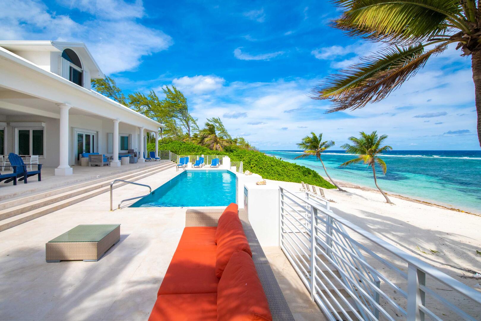 Large pool deck with veranda dining table, sun deck, and sofa lounge. 