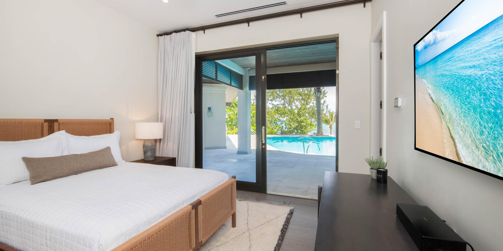 Bedroom 2 with king bed, SmartTV, ocean views, and walk-out access to the pool deck. 