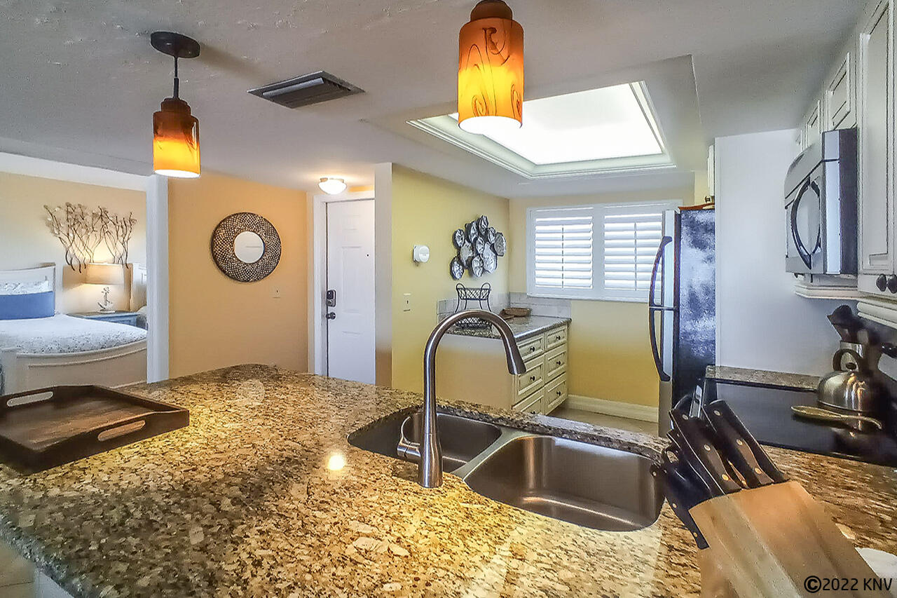 Kitchen has granite countertops and pendant lighting
