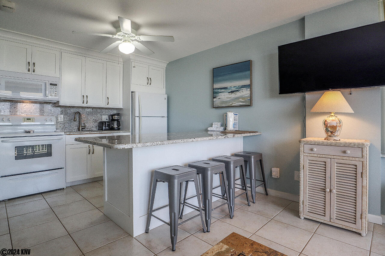 Four stools and a large granite countertop offer guests a comfortable way to dine
