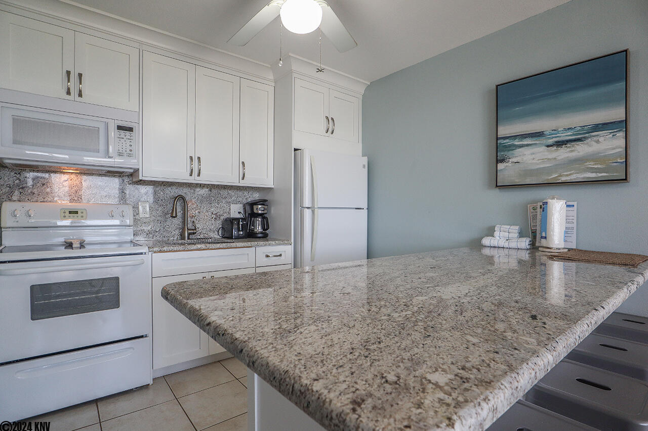 White granite countertop offers a wonderful spot to prep meals 
