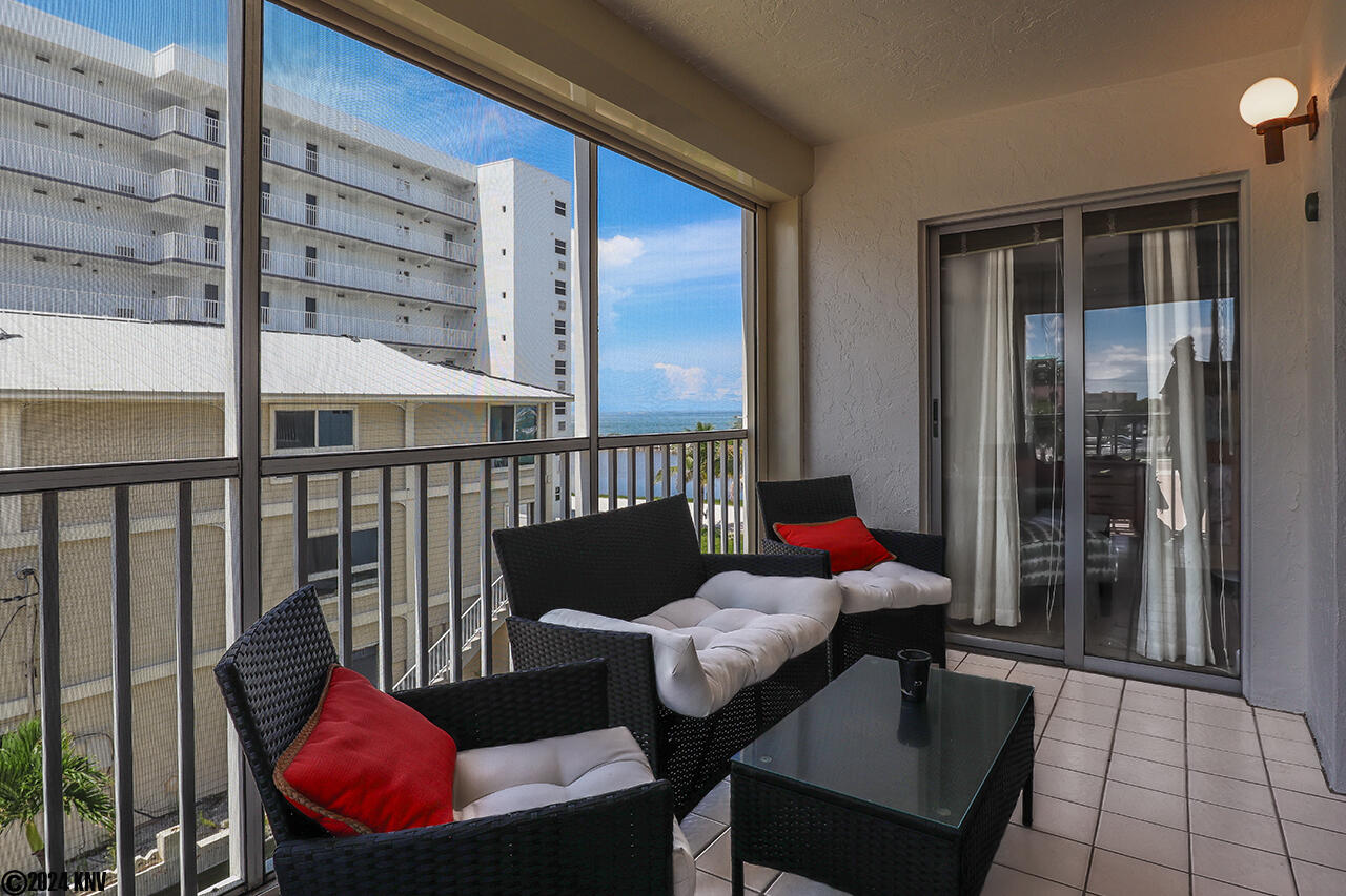 Lovely Screened In Lanai features patio furniture where you can relax and enjoy the sea breezes