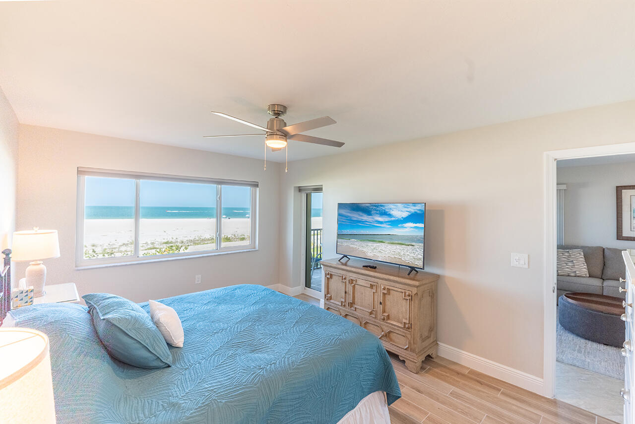 Sink into crisp white linens in your serene master bedroom, where coastal views and gentle breezes create the perfect retreat.