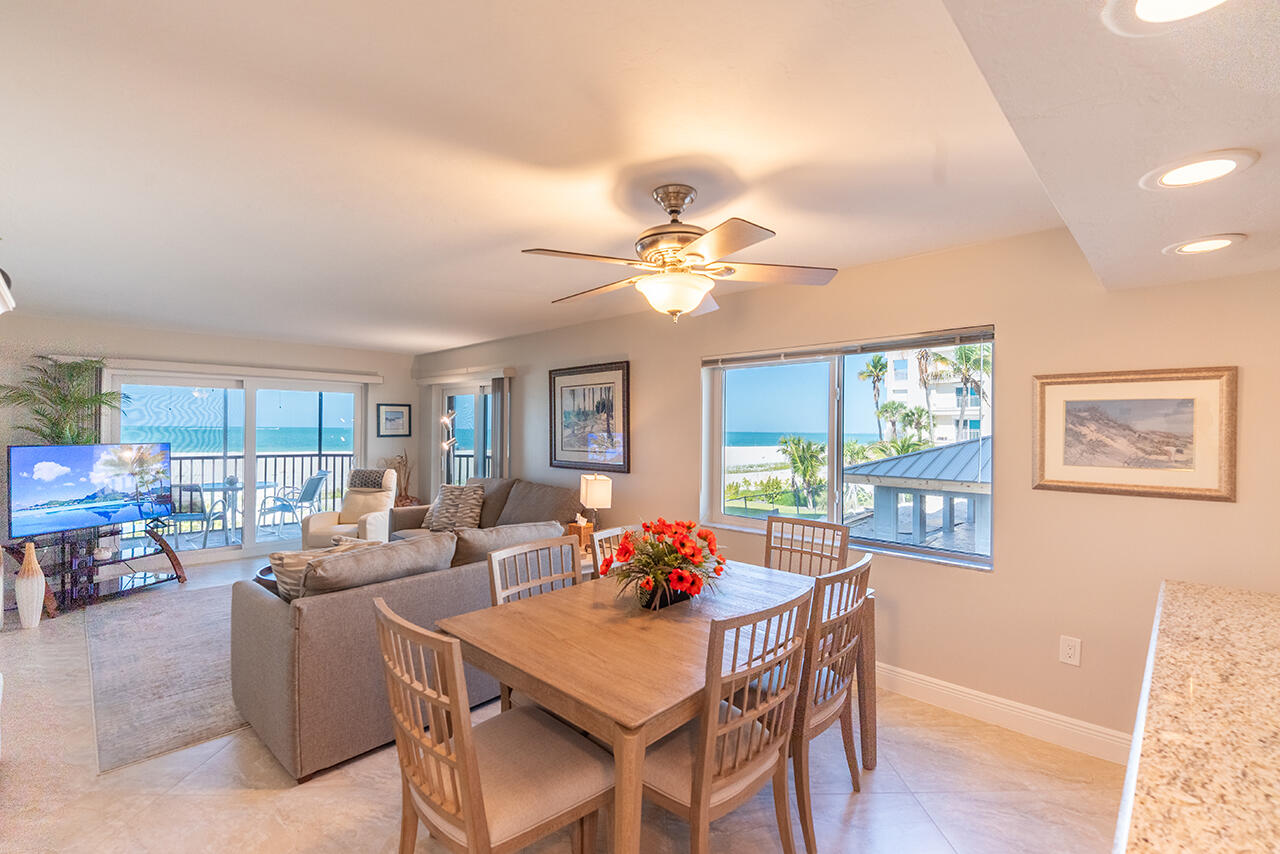 Gather around the elegant dining table where every meal becomes special. Natural light flows through windows offering glimpses of swaying palms.